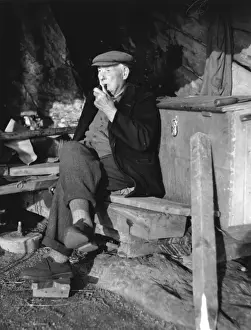 Fisherman at Torcross Print, a man smoking his pipe on a wooden plank