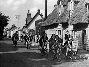 Prints of Jolly Hockey sticks! Its the Rosslyn Ladies Cycling Club, causing quite a stir as they cycle through the village of Hadham Cross, Hertfordshire, England. 1930s Hertfordshire Prints: Rosslyn Ladies Cycling Club, Hadham Cross, Hertfordshire Print 1930s