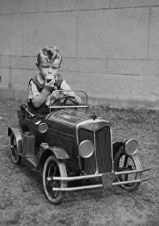 Little boy sitting in a toy car Our beautiful Wall Art and Photo Gifts include Framed Prints Photo Prints Poster Prints Canvas Prints Jigsaw Puzzles Metal Prints and so much more