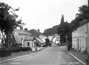 Prints of Loughgall - a deserted street scene showing buildings either side of the road. (Location: Northern Ireland; County Armagh; Loughgall). Date: circa early 1900s County Armagh Prints: Loughgall Loughgall Deserted Street Scene Print circa 1900s