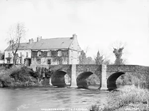 Prints of Maguiresbridge, Co Fermanagh - a view of a stone bridge over a river and buildings to the left. (Location: Northern Ireland; County Fermanagh; Maguiresbridge). Date: circa early 1900s Northern Ireland Prints: Early 20th Century Print of Maguiresbridge, Co Fermanagh