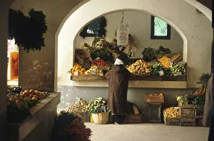 Man stands at a fruit and vegetable stall in Djerba, Tunisia Man stands at a fruit and vegetable stall in Djerba, Tunisia