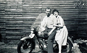 Man & woman on 1950s Triumph motorcycle Man & woman on 1950s Triumph motorcycle