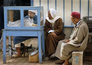 Two men by food stall in the market at Houmt Souk, Djerba Two men by food stall in the market at Houmt Souk, Djerba