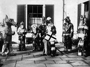 Prints of The ancient medieval Mumming plays, revived by a troop of Boy Scouts at Minstead, New Forest, England. They look quite a spectacle in their streamers and wooden hats! Date: 26 December (Boxing Day) Cultural Festivals And Tradition Prints: Minstead Mummers: A Boxing Day Revival Print, 1920s