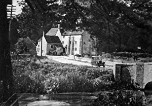 Morris Minor driving through English village Morris Minor driving through English village