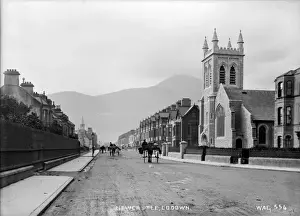 Prints of Newcastle, Co Down - a main street scene with horse vehicles and large church on the right. (Location: Northern Ireland: County Down: Newcastle). Date: circa early 1900s Down Prints: Early 20th Century Print of Newcastle, Co Down