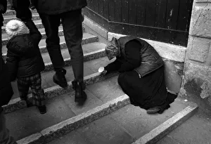 An old woman holds out a cup to beg on a Venice bridge An old woman holds out a cup to beg on a Venice bridge