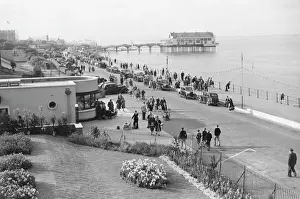 Prints of The parade at Cleethorpes in Lincolnshire, packed with parked cars and people making the most of a summer stroll along the sea front, perhaps to visit the big wheel or pier Date: 1951 Lincolnshire Prints: 1951 Print of Cleethorpes Summer Parade