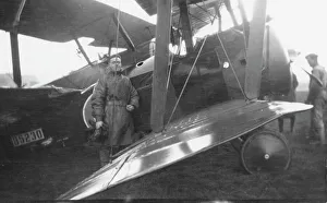 Pilot standing with biplane on an airfield, WW1 Pilot standing with biplane on an airfield, WW1