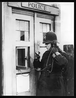 Prints of A police constable using the telephone at a police box Police Prints: Police Box Print - Constable at Telephone