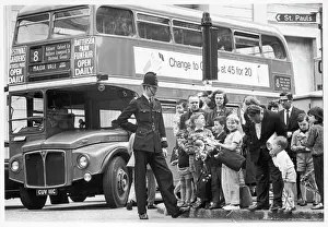 Prints of A policeman keeps his eye on a crowd of young sightseers, keeping them on the pavement and well out of the path of the No. 8 Routemaster bus to Maida Vale, London Bus Prints: London Street Scene Print