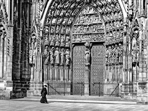 Priest walking in front of Strasbourg Cathedral, France Priest walking in front of Strasbourg Cathedral, France