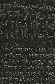 Print of the Rosetta Stone, a black granite stele with hieroglyphic and demotic inscriptions