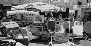 Sleeping man at antique stall, Duras, France Sleeping man at antique stall, Duras, France