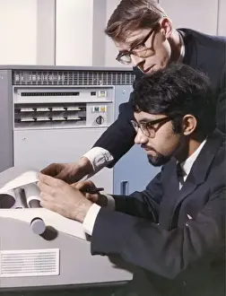 Heinz Zinram Photography Prints: Two technicians check a computer printout