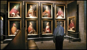 Tourist looking at portraits of Avignon popes, France Tourist looking at portraits of Avignon popes, France