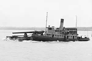 A Tugboat with barge carrying cannon in America A Tugboat with barge carrying cannon in America