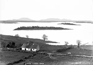 Prints of Upper Lough Erne - an elevated view of the Lough and islands with a thatched cottage in the foreground. (Location: Northern Ireland; County Fermanagh; Lough Erne). Date: circa early 1900s Fermanagh Prints: Early 20th Century Print of Upper Lough Erne