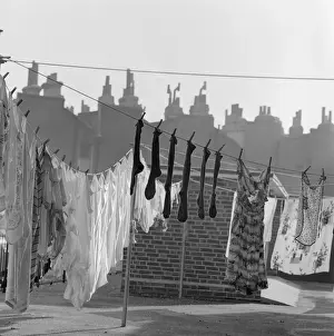 Prints of Lines of washing drying in the sun with the outlines of roofs and chimney pots behind, in an unidentified location in either Islington or Camden, in London Islington Prints: Lines of Washing Drying in the Sun Print