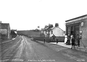 Prints of Windmill Hill, Ballyholme - a street scene with the post office on the right (with assembled people) and the windmill to the distance. (Location: Northern Ireland: County Down: Bangor) Down Prints: Early 20th Century Ballyholme Street Scene Print
