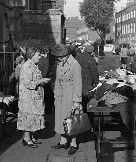 Two women chat at second hand clothes stall, London Two women chat at second hand clothes stall, London