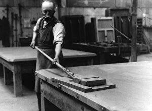 Accrington Collection: A workman smoothing the surface of the slate bed of a billiard table at a factory in