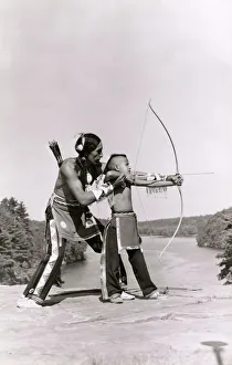 Young Native American Indian boy learning to shoot his bow Young Native American Indian boy learning to shoot his bow