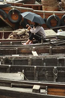 A young woman on a small sampan wooden ferry boat A young woman on a small sampan wooden ferry boat