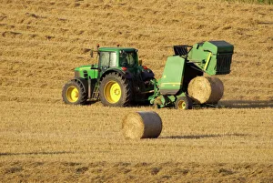 Tractor stopping to allow hay bale making machine to release bale of hay - September Tractor stopping to allow hay bale making machine to release bale of hay - September