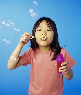 Young Girl Playing Outside Prints: Blowing bubbles