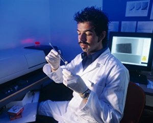 Prints of MODEL RELEASED. Bone CT scanning. Radiologist with a bone biopsy sample that he is preparing for CT (computed tomography) scanning using specialized equipment for small samples Images Dated 2003 November: Bone CT scanning Print: Radiologist prepares biopsy sample for analysis