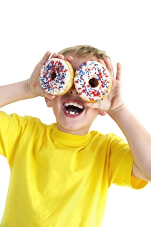 Images Dated 2nd January 2007: Boy playing with doughnuts Print