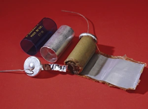 Prints of Dismantled capacitor. This is a device designed to store and release electric charge. The charge is stored in a rolled up cylinder of material seen at centre (brown) Images Dated 2005 January: Dismantled Electrolytic Capacitor Print