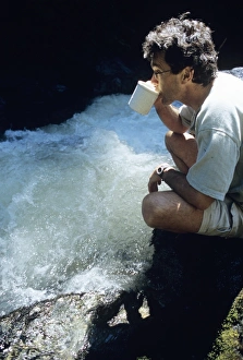 Print of a man drinking from a glacial stream