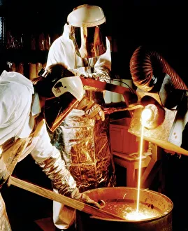 Foundry workers pouring molten metal into an ingot Foundry workers pouring molten metal into an ingot