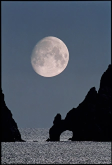 Gibbous moon rising over a coastal cliff Gibbous moon rising over a coastal cliff