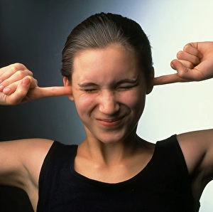 Hearing a loud sound: girl plugs ears with fingers Hearing a loud sound: girl plugs ears with fingers