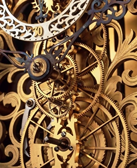 Prints of Clock cogs. Internal gears and cogs in an antique clock on a decorative background. At upper left is the pivot for the hour and minute hands; at top left is part of the seconds face Images Dated 2003 June: Internal Gears Print