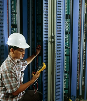 Man testing circuit boards at telephone exchange Man testing circuit boards at telephone exchange