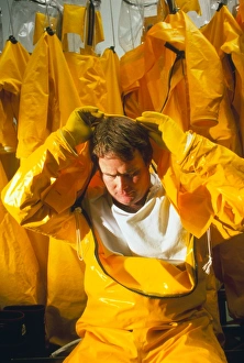 Pharmaceutical worker putting on a protective suit Pharmaceutical worker putting on a protective suit