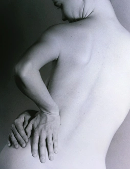 Posterior view of a naked woman with back pain Posterior view of a naked woman with back pain
