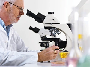 Scientific Research Tools Prints: Scientist using a light microscope F006 / 9023