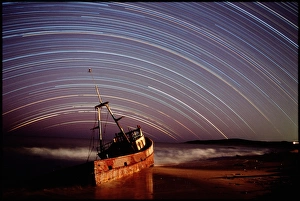Star trails over rusted boat wreck Star trails over rusted boat wreck