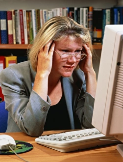 Stressed and tired woman at an office computer Stressed and tired woman at an office computer