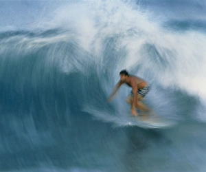 Surfer riding a breaking wave in Hawaii Surfer riding a breaking wave in Hawaii