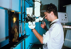 Technician examines forged painting by microscope Technician examines forged painting by microscope