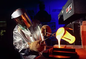 Technician pours molten glass from a crucible Technician pours molten glass from a crucible