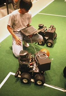 Technician programs robot footballer at RoboCup-98 Technician programs robot footballer at RoboCup-98