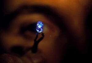 View of a man holding a blue light emitting diode View of a man holding a blue light emitting diode